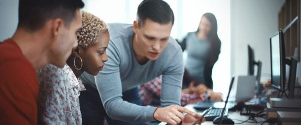 a group of people looking at a laptop