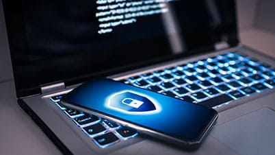 a blue cell phone on a laptop