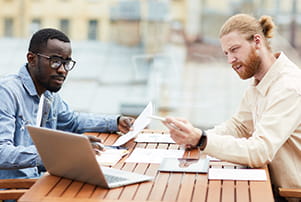 a couple of men looking at a laptop a couple of men looking at a laptop