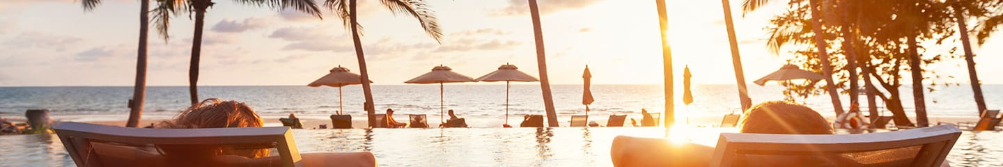 a group of people sitting in lounge chairs on a beach