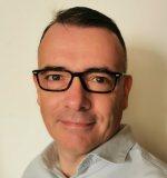 a man wearing glasses and smiling at the camera