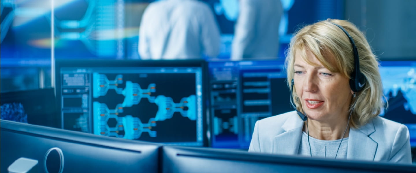 A woman on a computer working in a control centre.