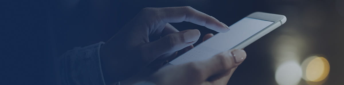 A hand typing with one finger on a smartphone.