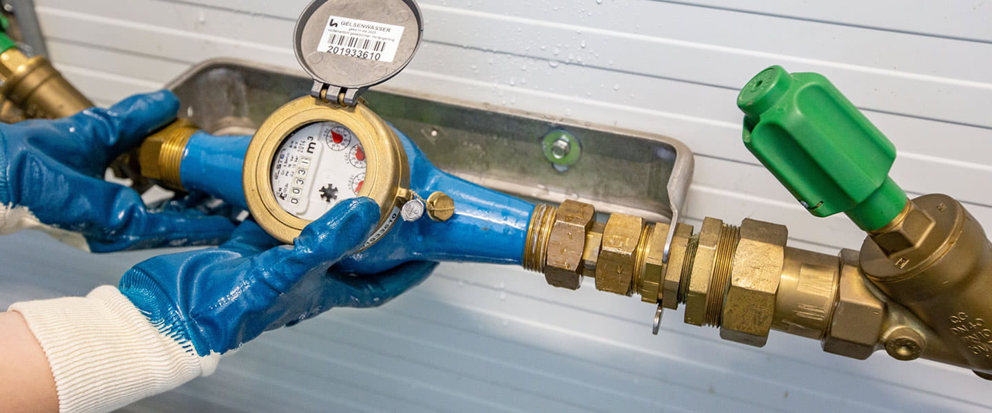 gloved hands holding a meter