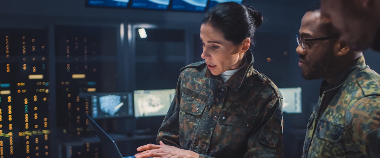 military personnel looking at a laptop