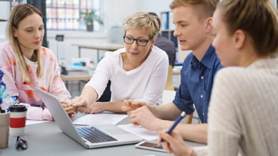 A group of people looking at a laptop. A group of people looking at a laptop.