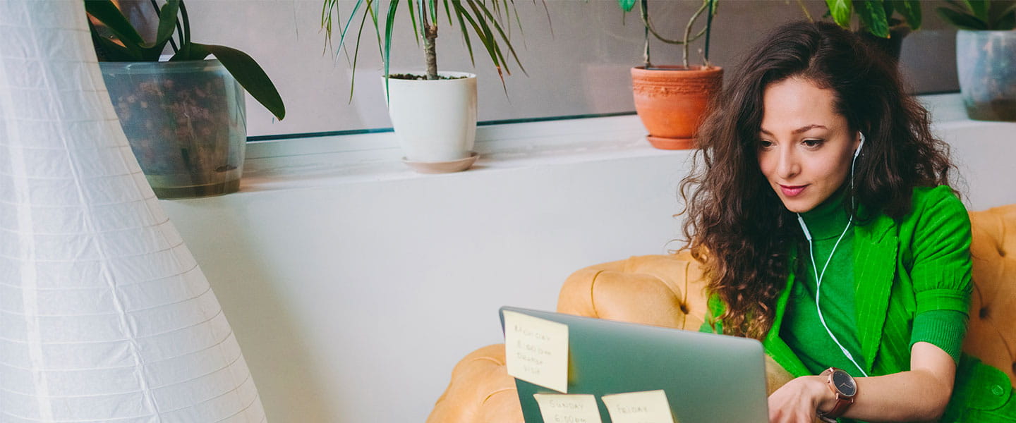 a woman sitting on a couch with a laptop