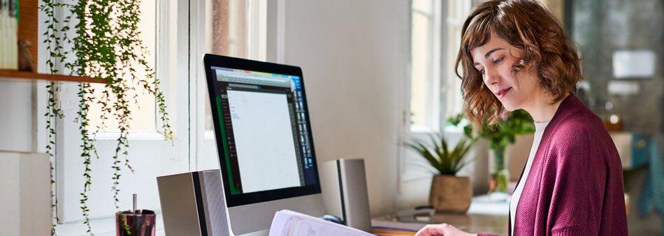a person sitting at a desk in front of a window