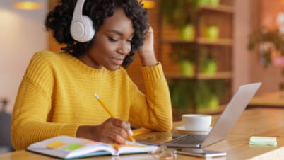 a women with headphones working on a laptop a women with headphones working on a laptop